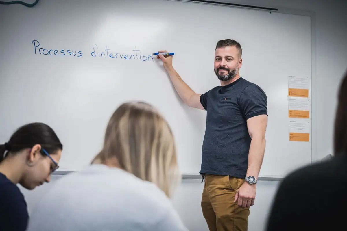 Personne qui écrit sur un tableau blanc