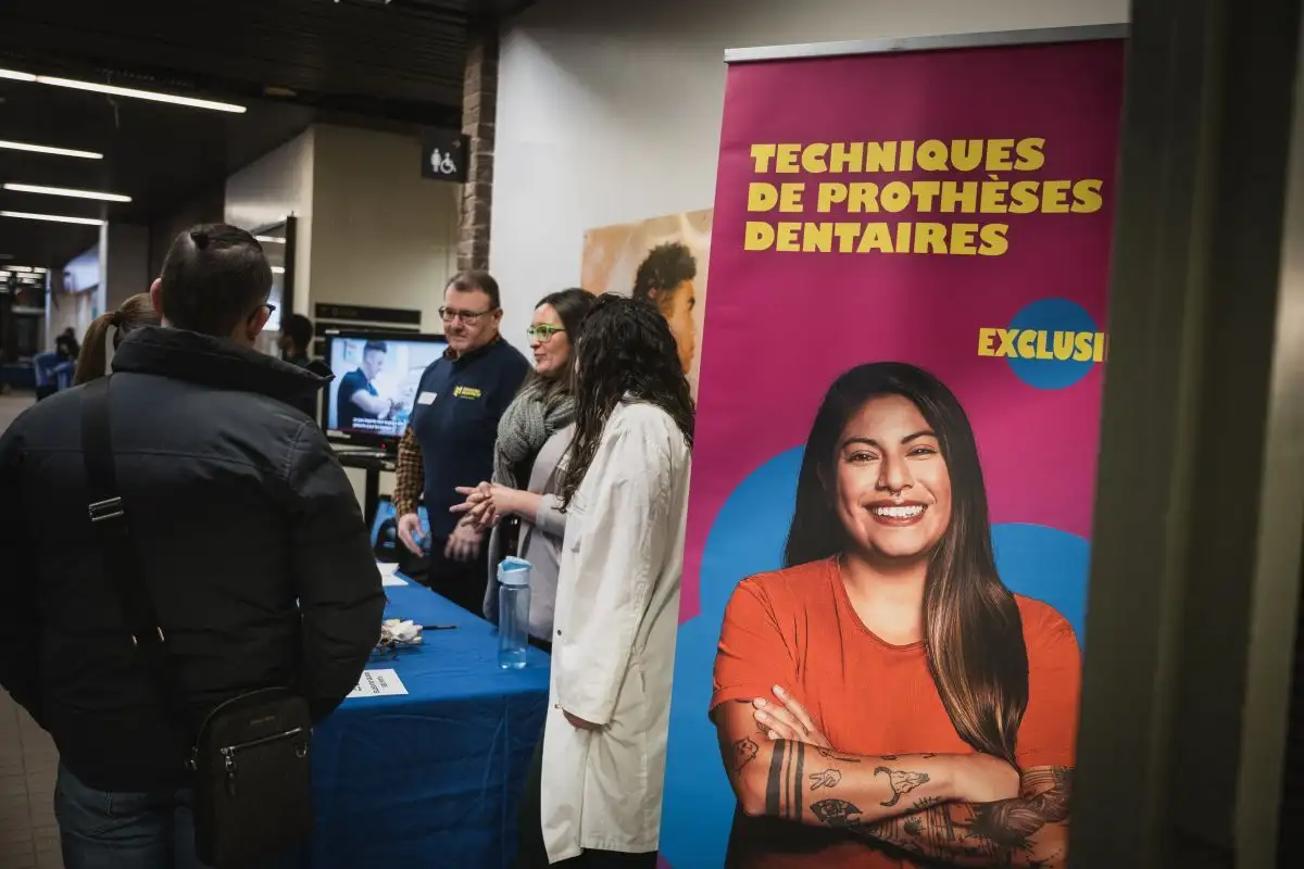 Personnes enseignantes en techniques de prothèses dentaires qui accueillent les visiteurs à leur stand