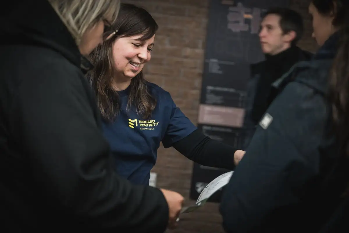 Une bénévole du Cégep qui indique le chemin à des personnes durant leur visite du Cégep