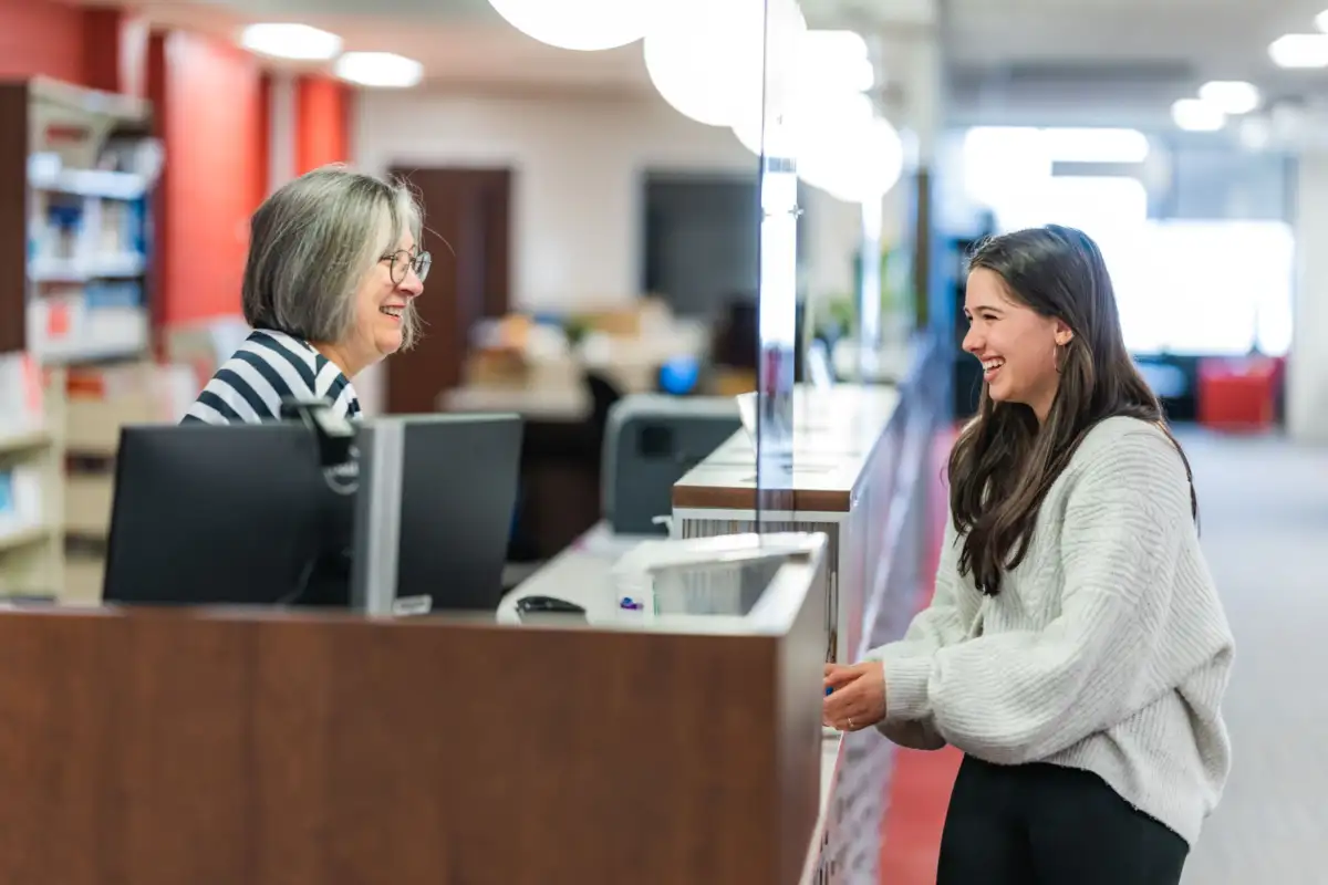 Étudiante au comptoir de prêt de la bibliothèque