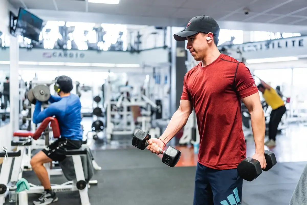 Personne qui s'entraine avec des altères à la salle Ben Weider