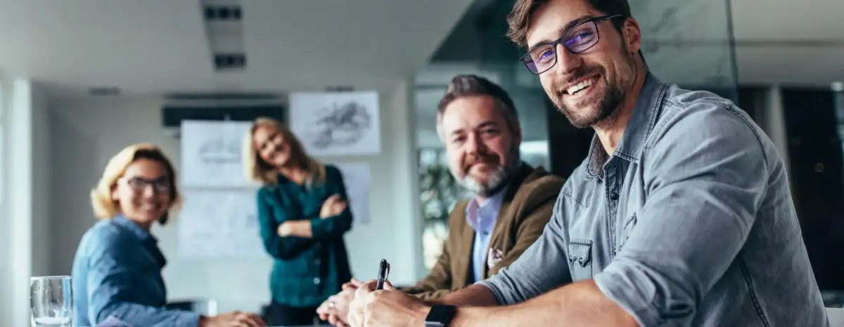Personnes professionnelles souriantes dans une salle de réunion