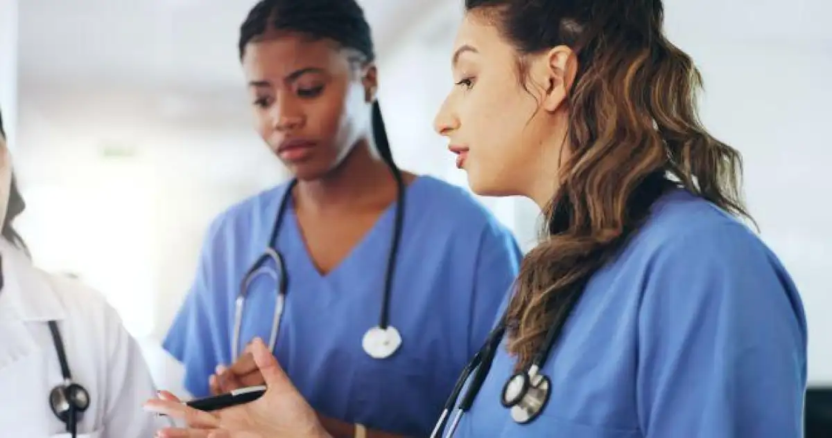 Deux infirmières discutant avec un médecin