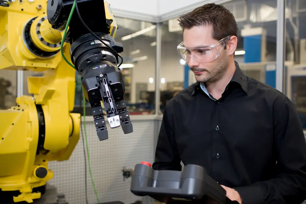 Un homme qui contrôle un bras robotique