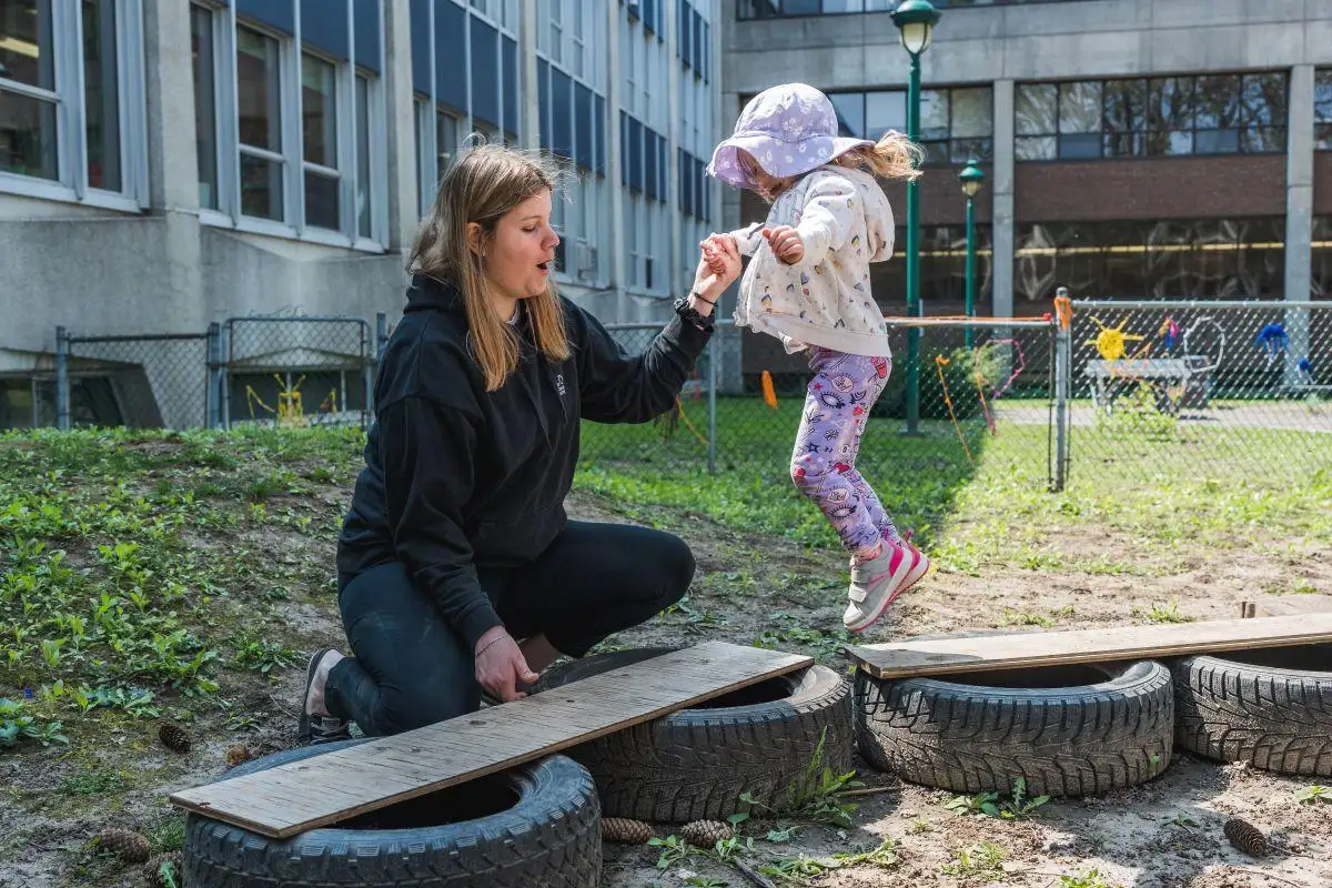 Éducatrice avec une enfant dans la cours extérieure