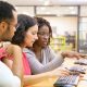 3 adultes en face d'un ordinateur qui discutent