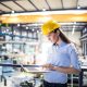 Femme tenant un ordinateur portable dans une usine