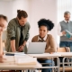 Plusieurs personne dans un local de formation avec deux sur un ordinateur
