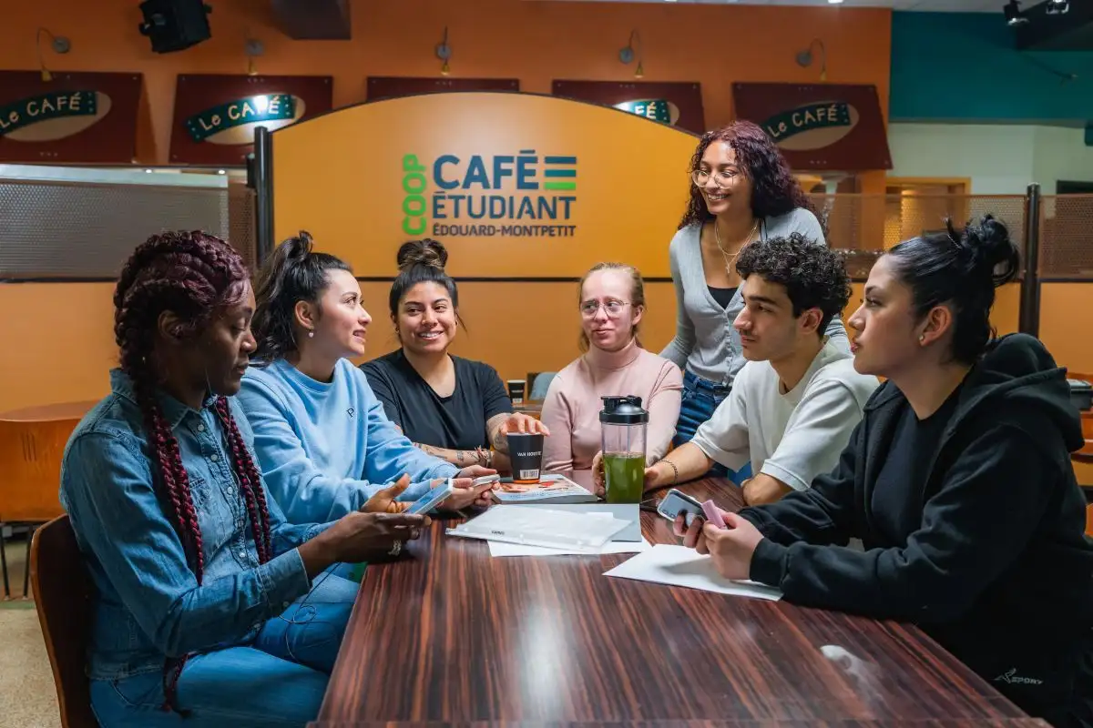 Personnes étudiantes autour d'une table au café étudiant