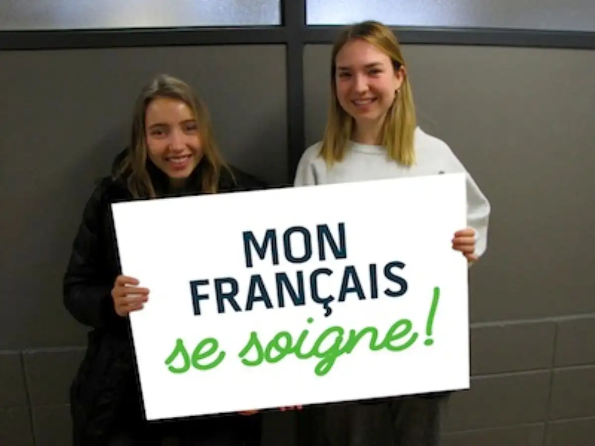 Étudiantes qui portent une pancarte "Mon français se soigne"