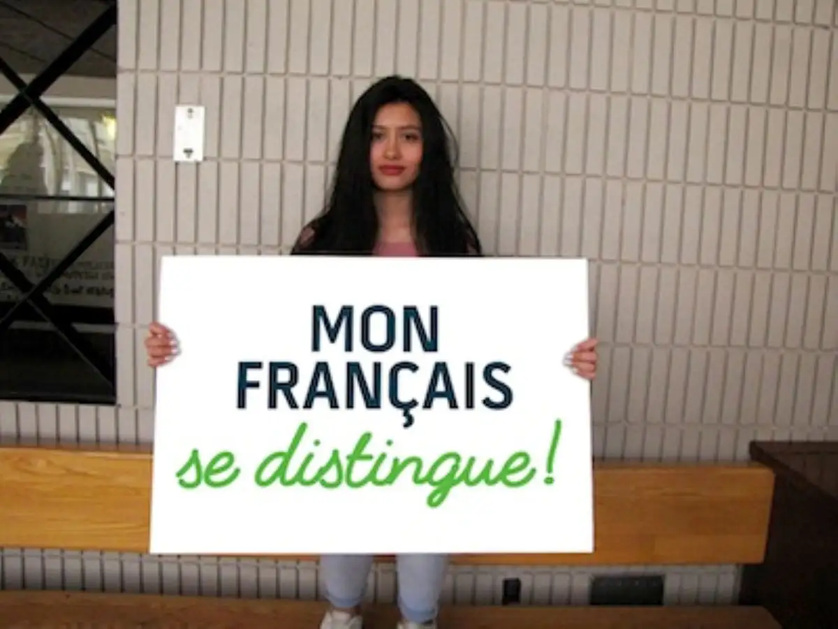 Étudiante qui portent une pancarte "Mon français se distingue"