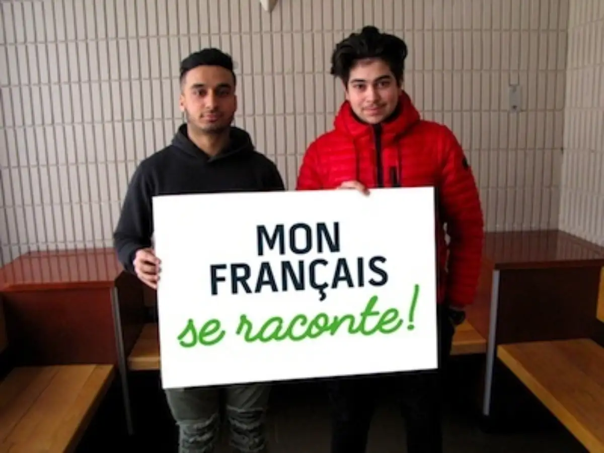 Étudiants qui portent une pancarte "Mon français se raconte"