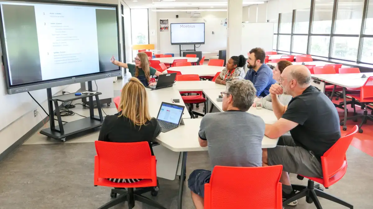 Personnes qui utilisent la classe d'apprentissage actif assises autour d'une table