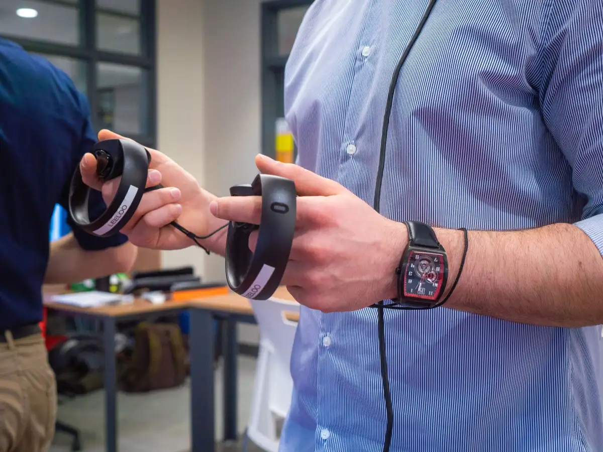 Mains qui manipulent les manettes du casque de réalité virtuelle