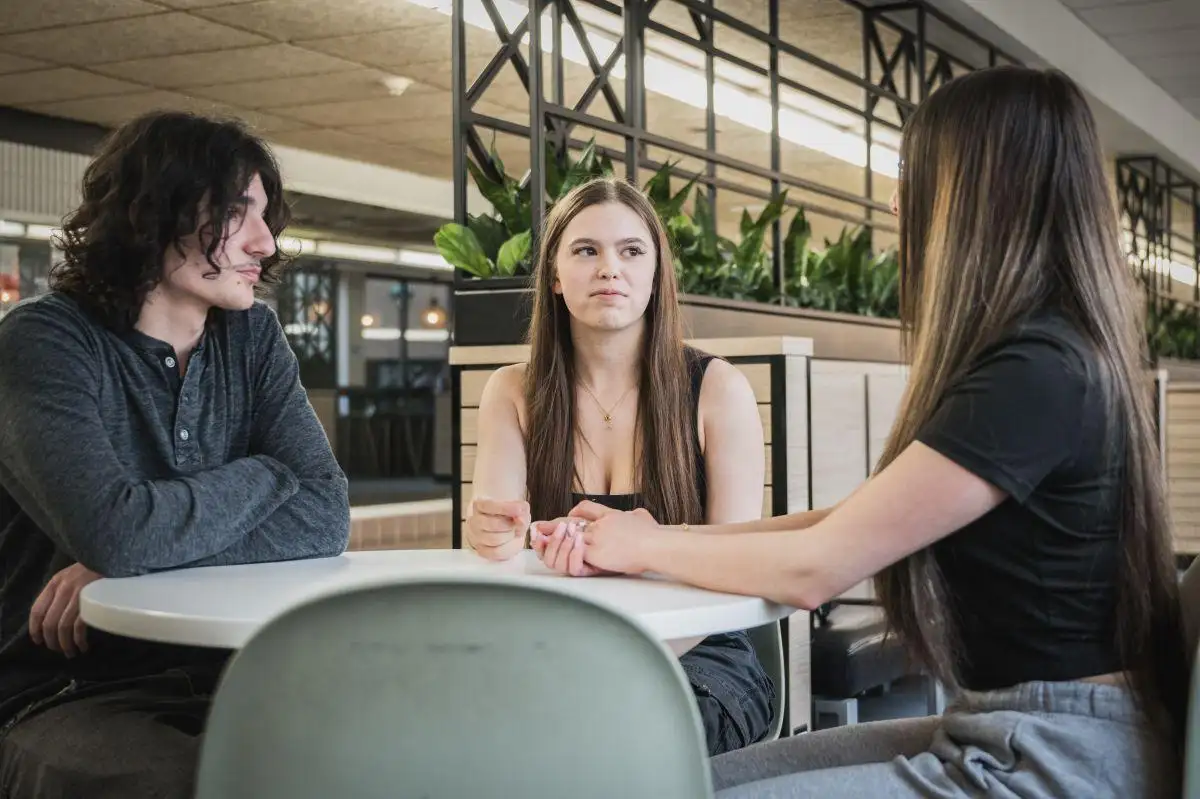 Personnes étudiantes à table dans le corridor de l'aile E