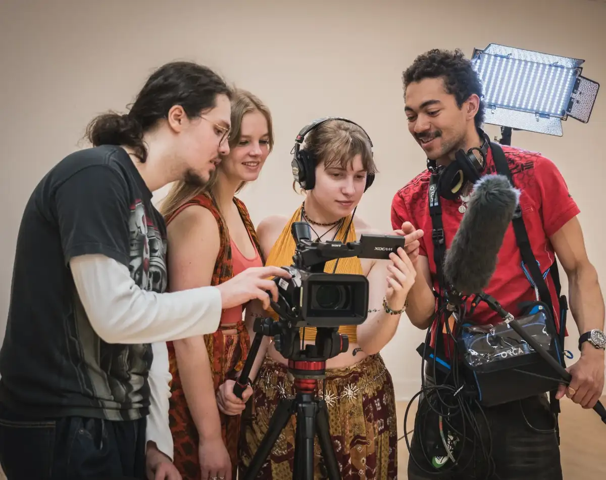 Personnes étudiantes autour d'une caméra