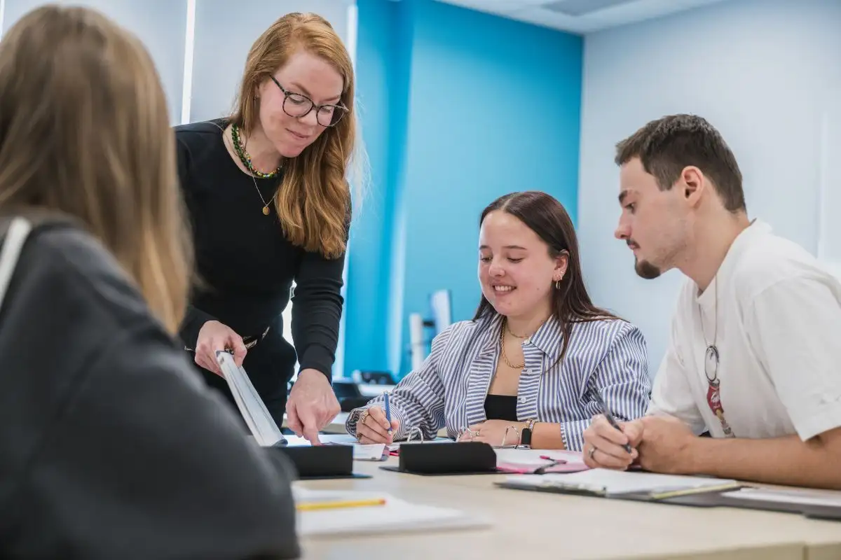 Enseignante qui échange avec ses personnes étudiantes à table