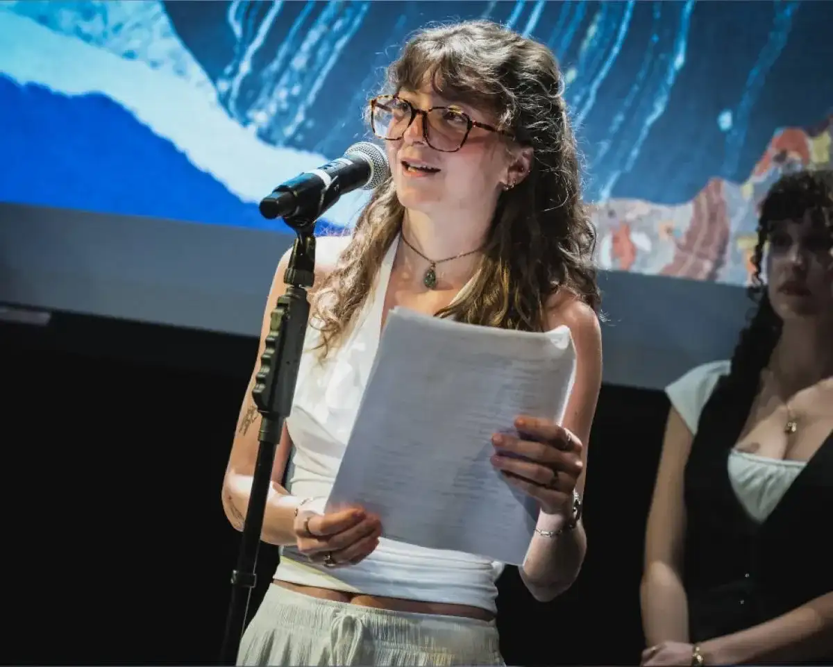 Étudiante qui lit un texte devant un micro