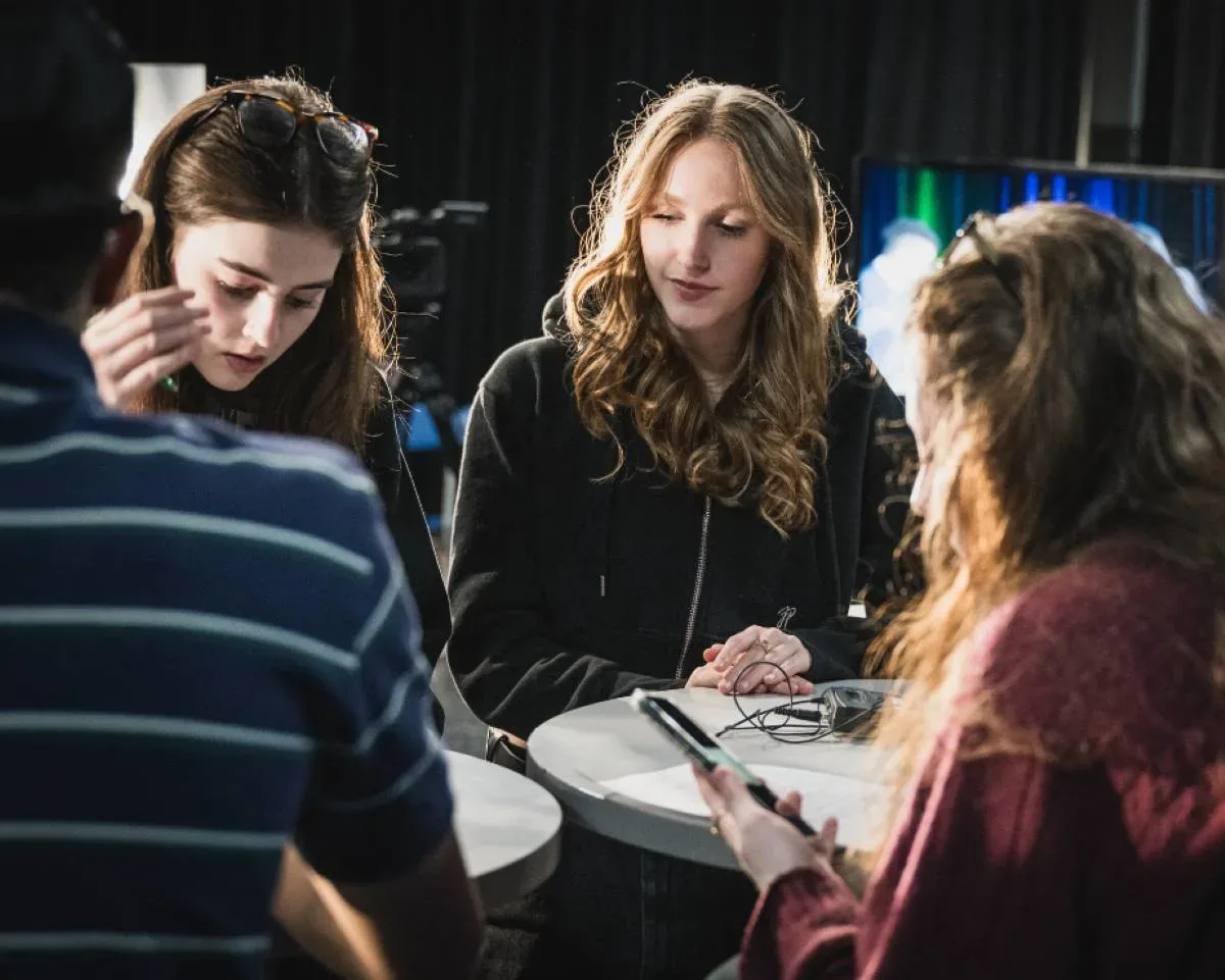 Personnes étudiantes autour d'une table haute