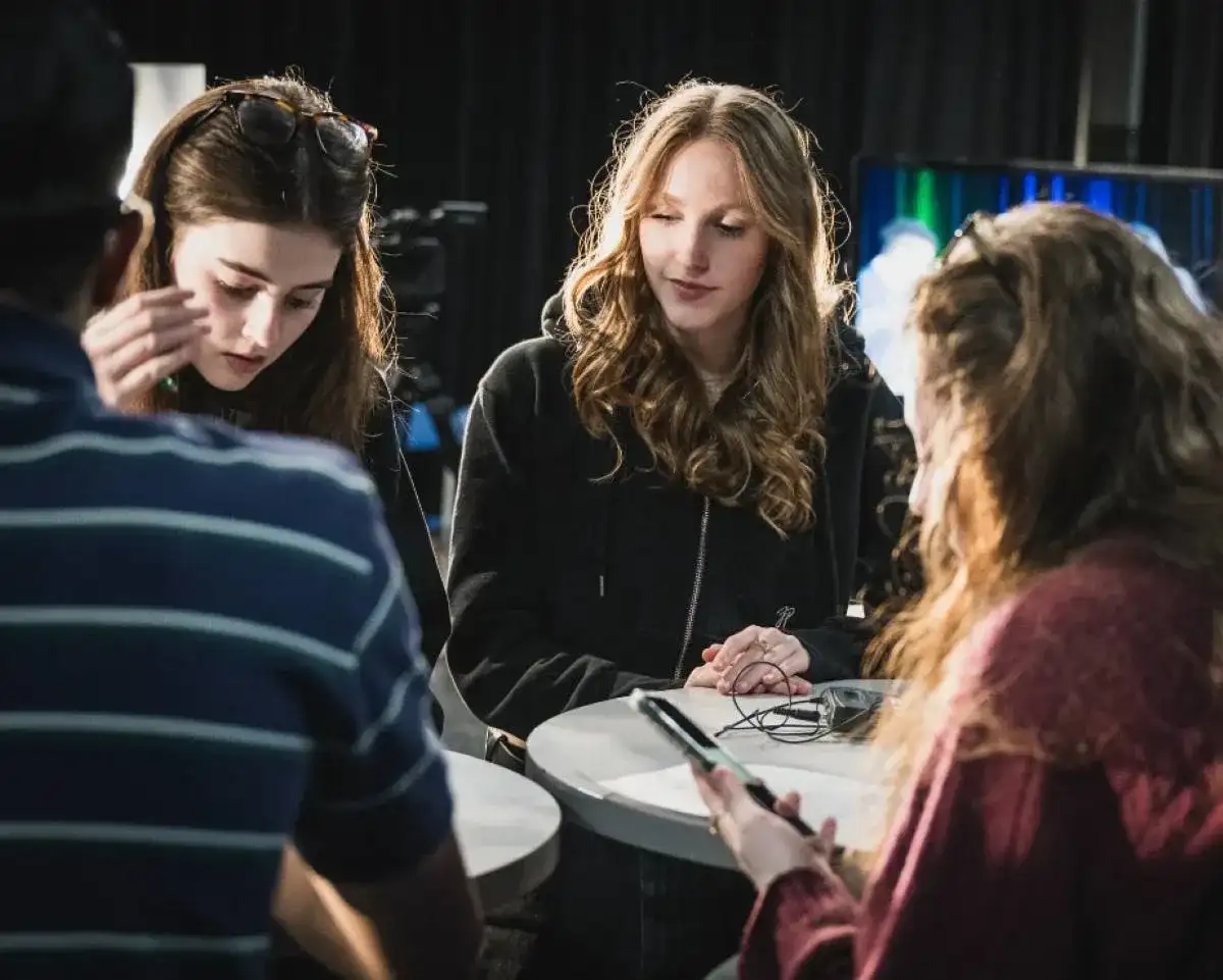 Personnes étudiantes autour d'une table haute