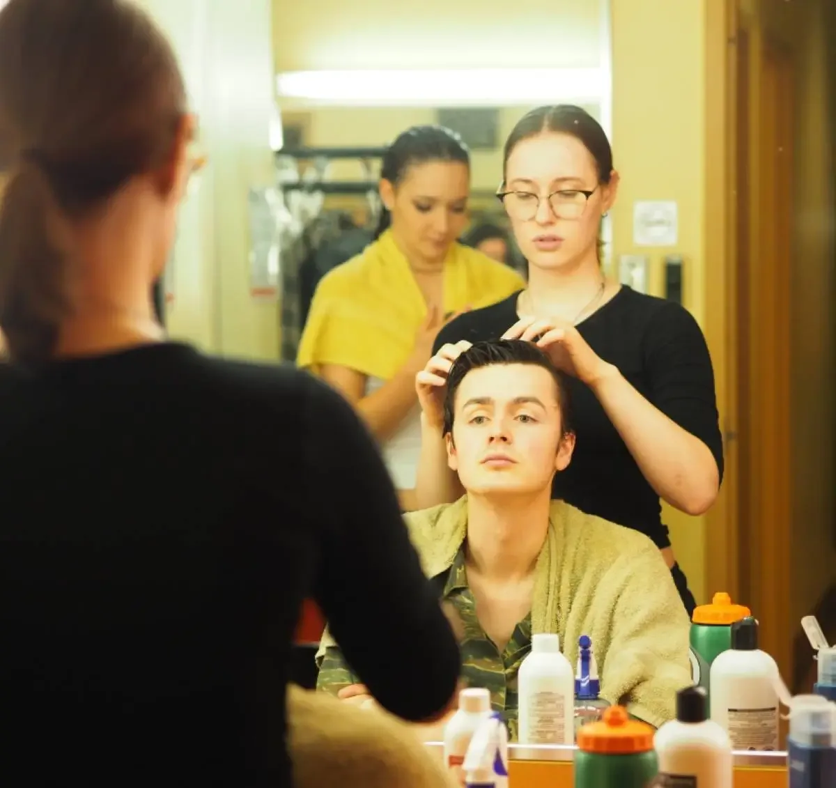 Étudiant qui se fait coiffer et maquiller