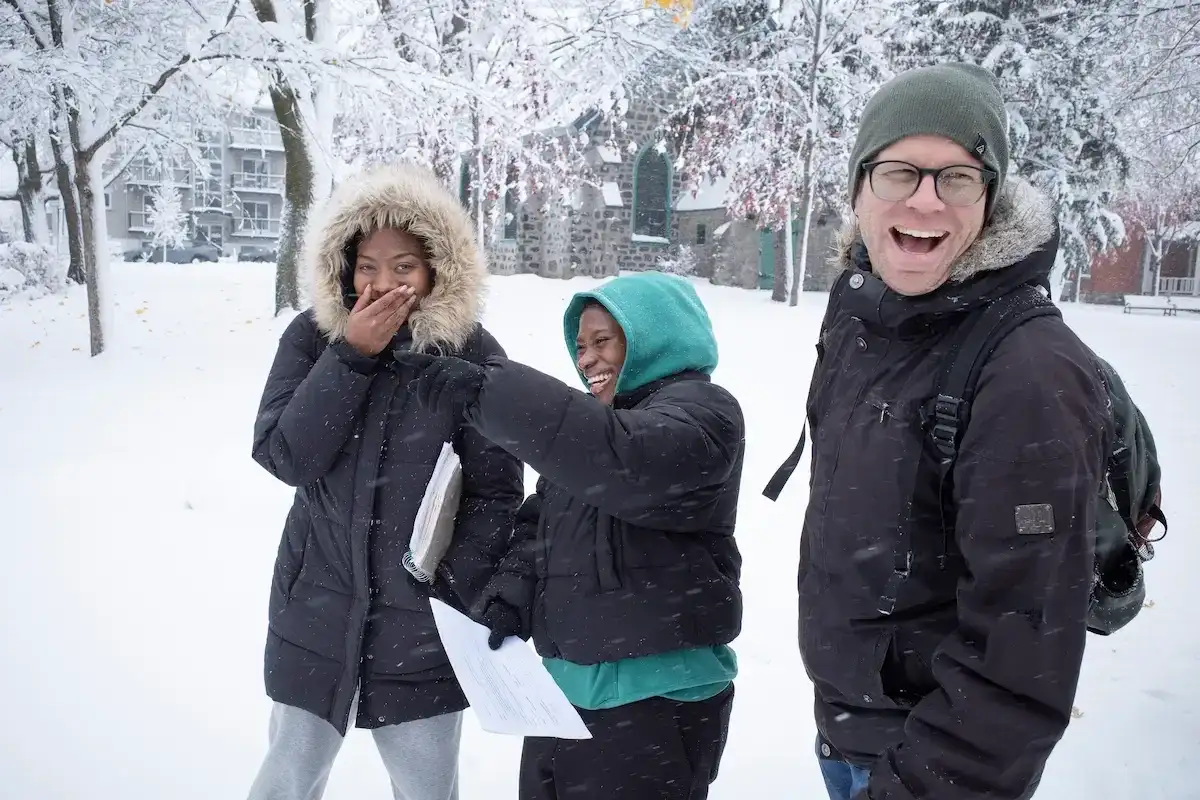 Deux étudiantes avec leur professeur dans la neige