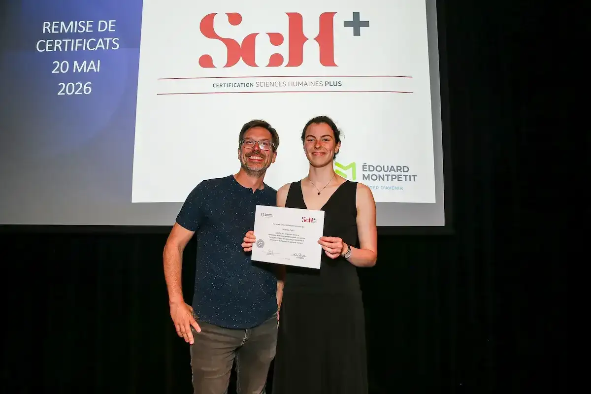 Une étudiante recevant un certificat, en compagnie de son professeur