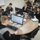 Personnes étudiantes dans une salle de classe autour d'ordinateurs