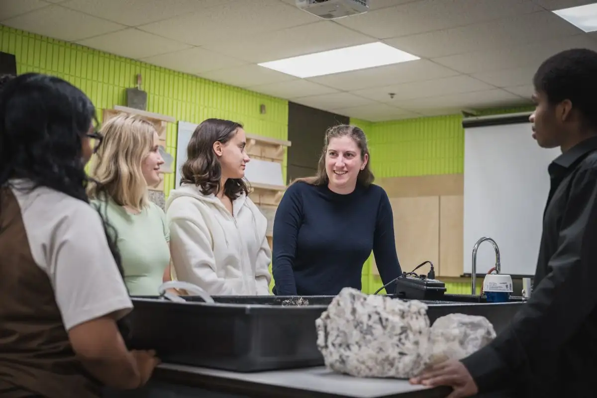 Enseignante entourée de ses personnes étudiantes