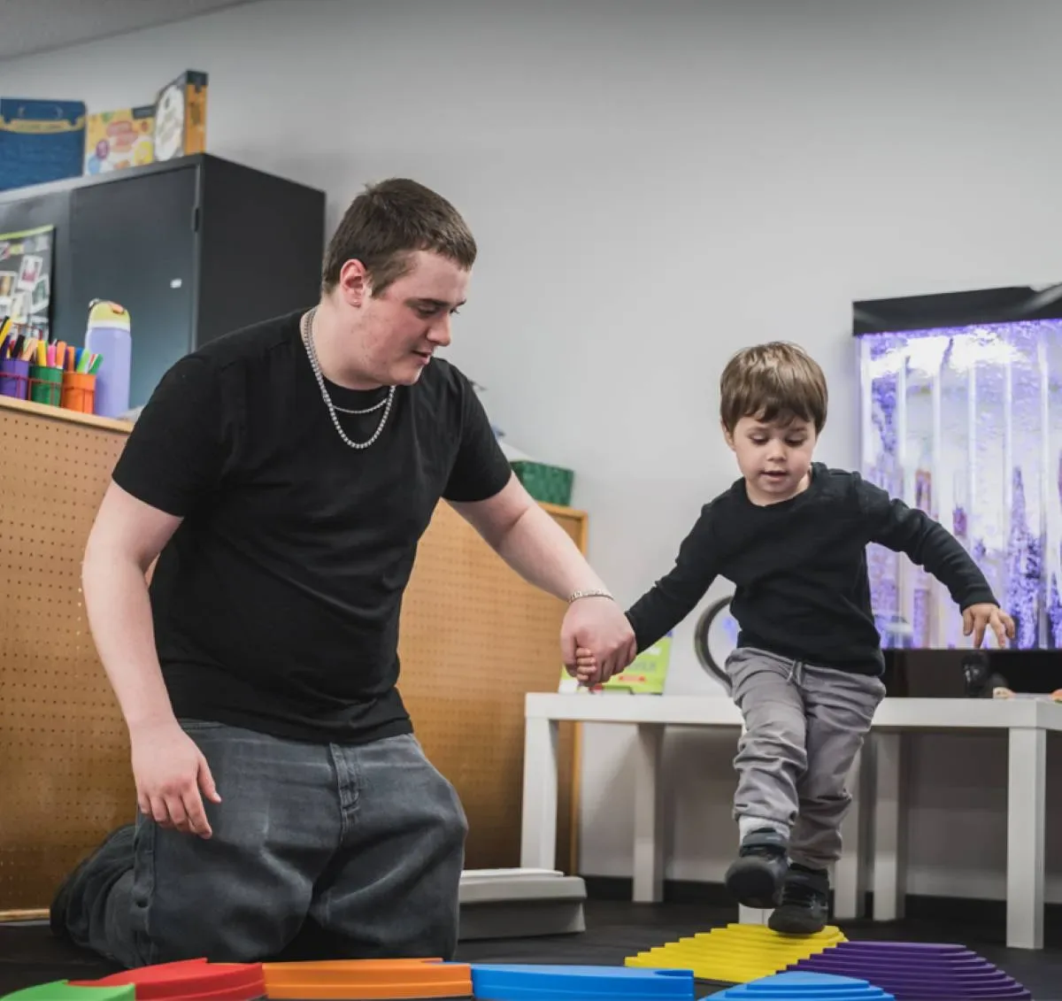 Étudiant qui aide un enfant avec des jeux de motricité