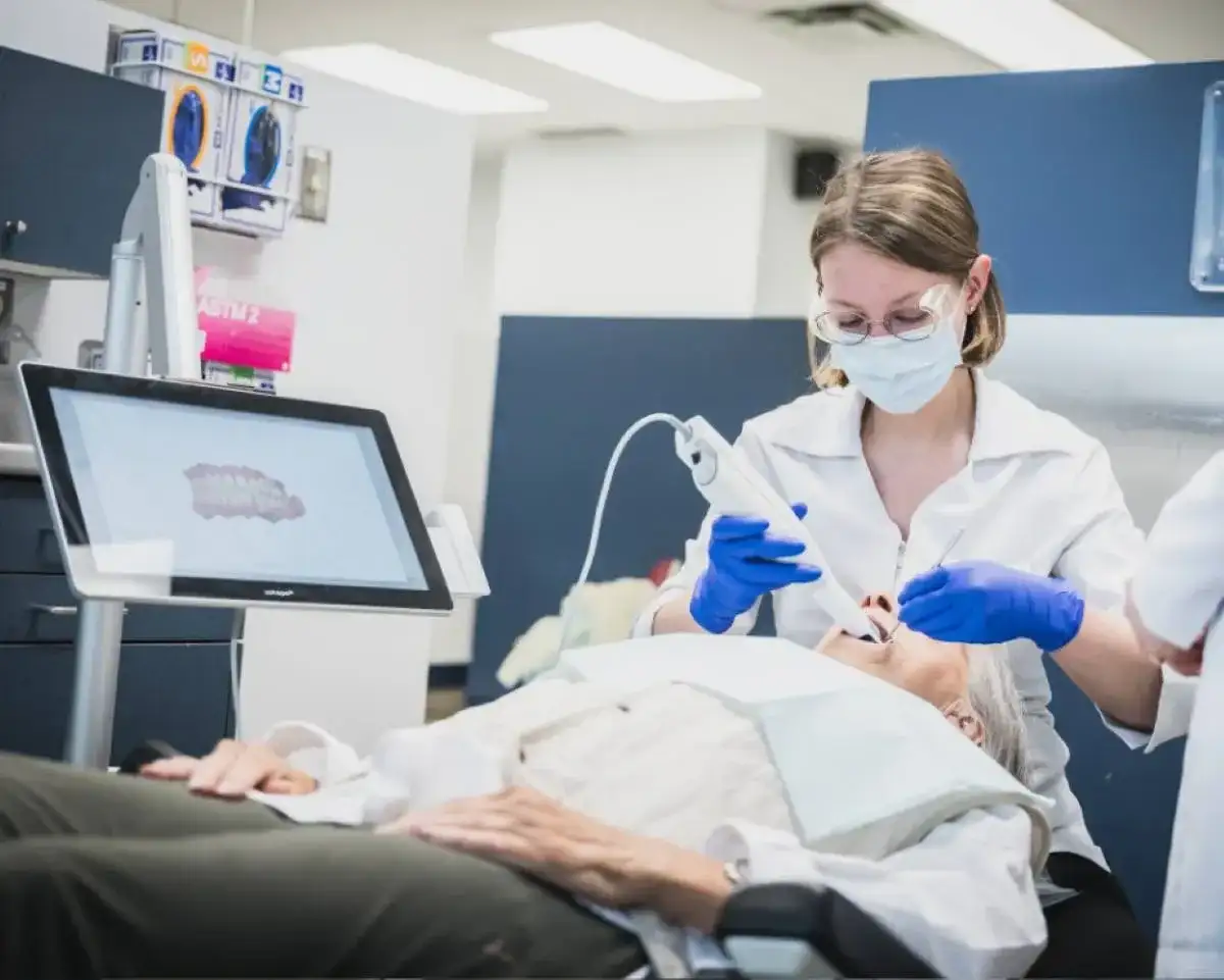 Étudiante qui effectue un examen buccal sur un patient
