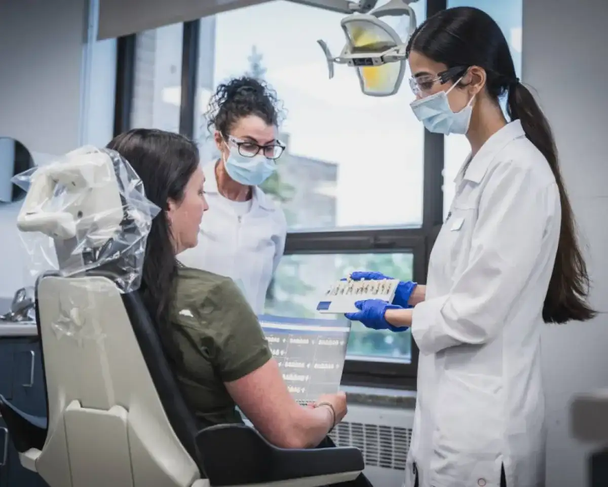 Étudiantes qui présentent des modèles à une patiente dans un fauteuil de consultation