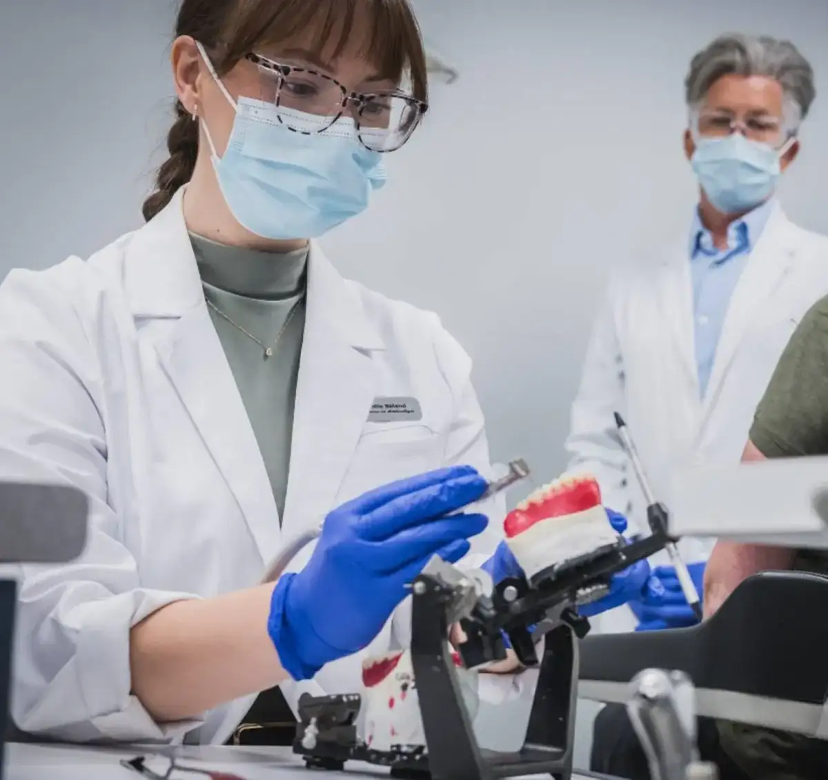 Étudiante qui manipule du matériel sous la supervision de son professeur