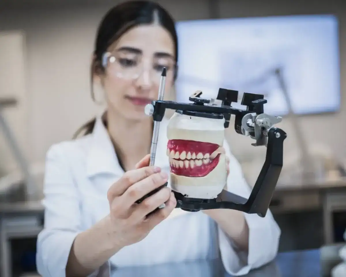 Personne étudiante qui prend les dimensions d'un dentier