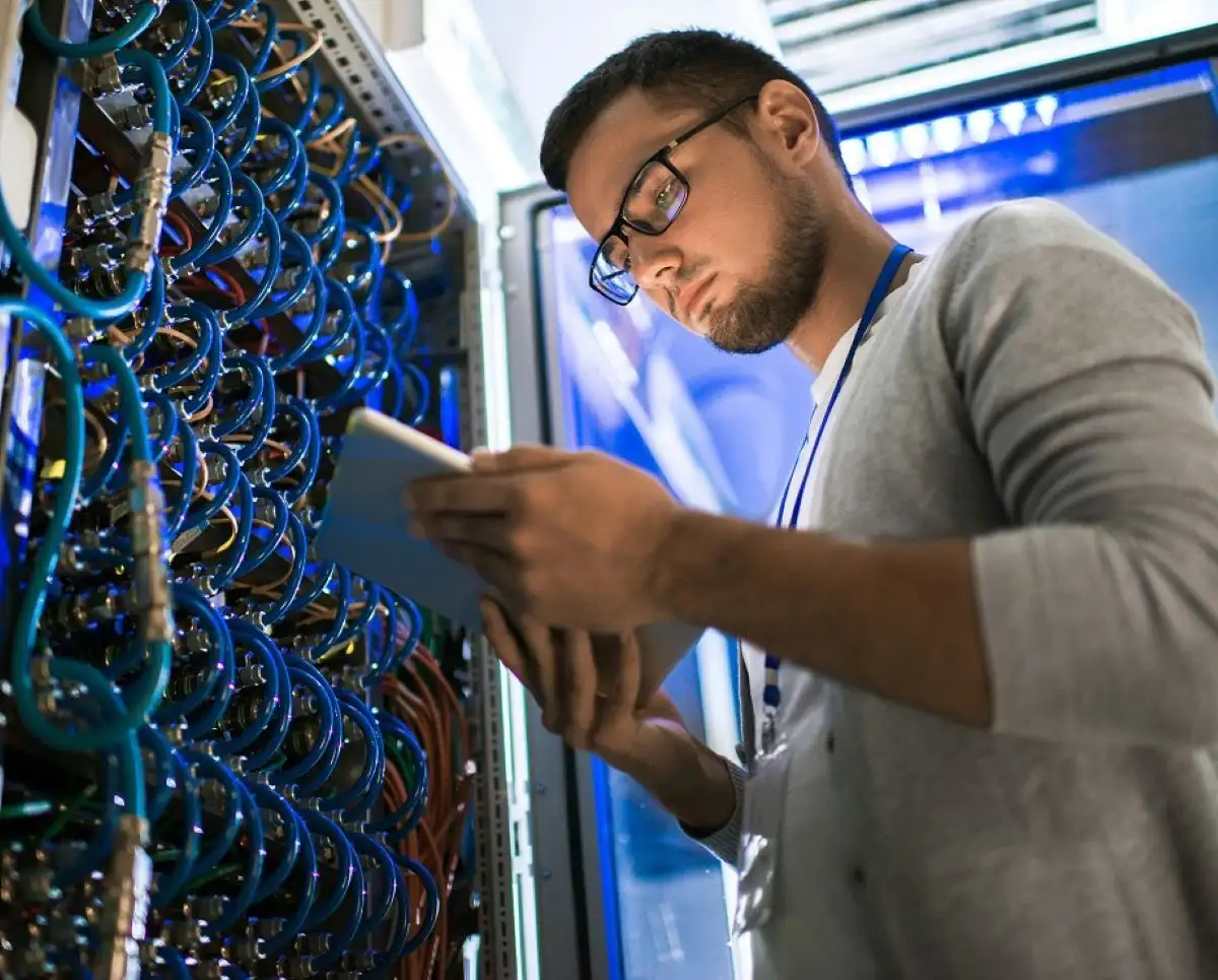 Étudiant qui effectue des vérifications devant un panneau de contrôle