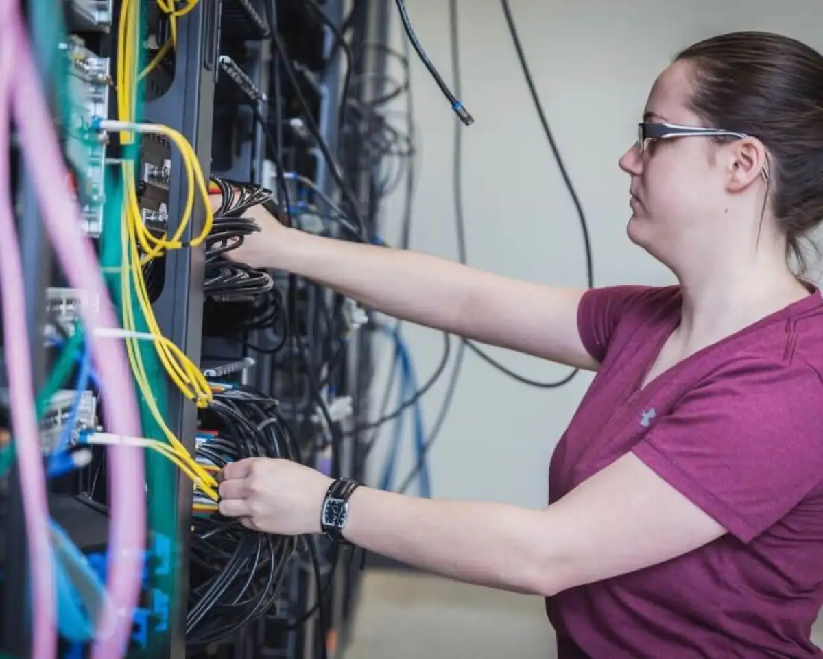 Étudiante qui vérifie des branchements de câbles de télécommunication