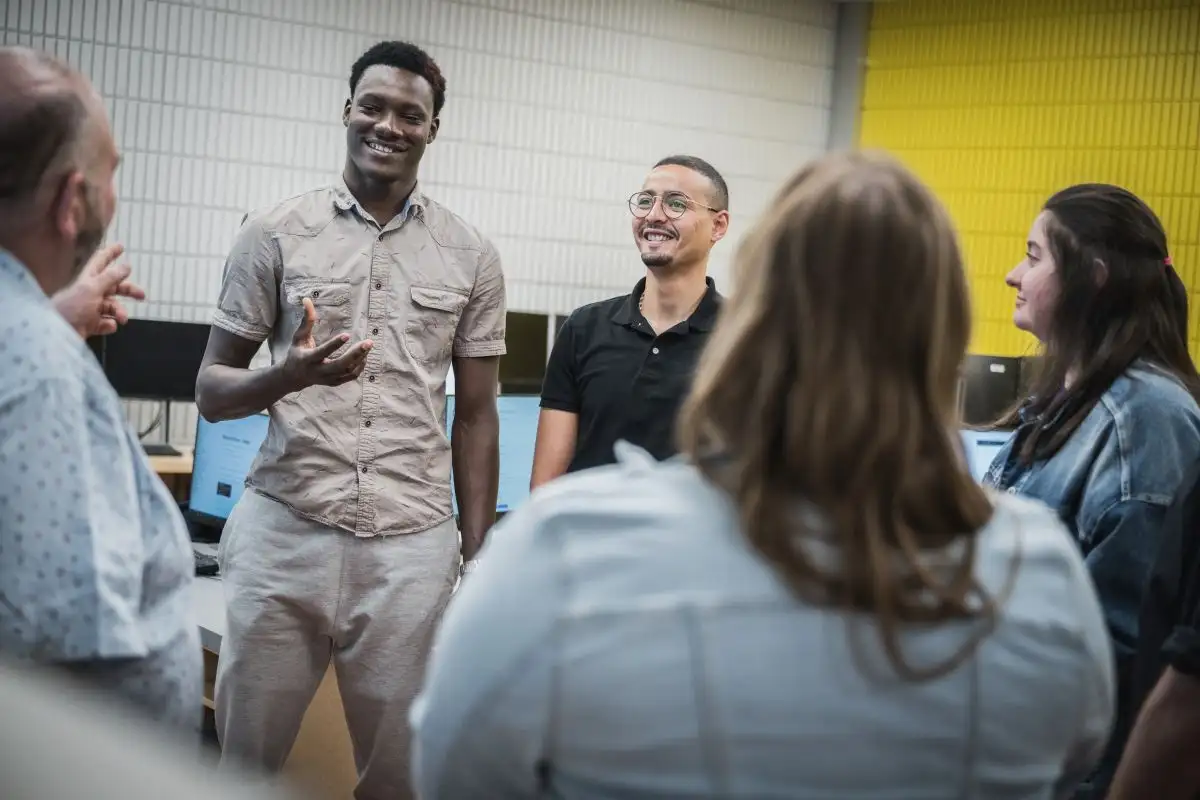 Personnes étudiantes qui discutent avec leur enseignant