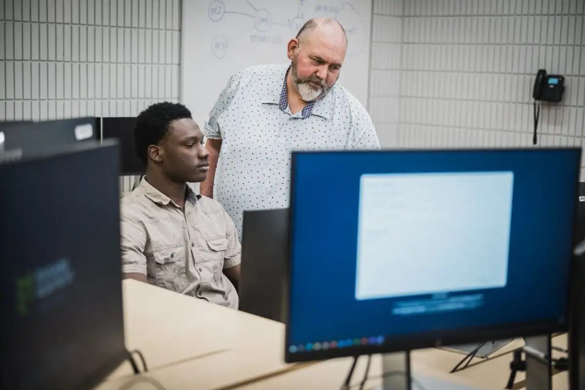 Enseignant et son étudiant devant l'ordinateur