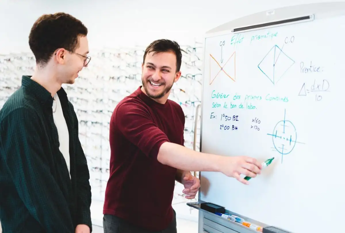 Enseignant et étudiant devant un tableau blanc