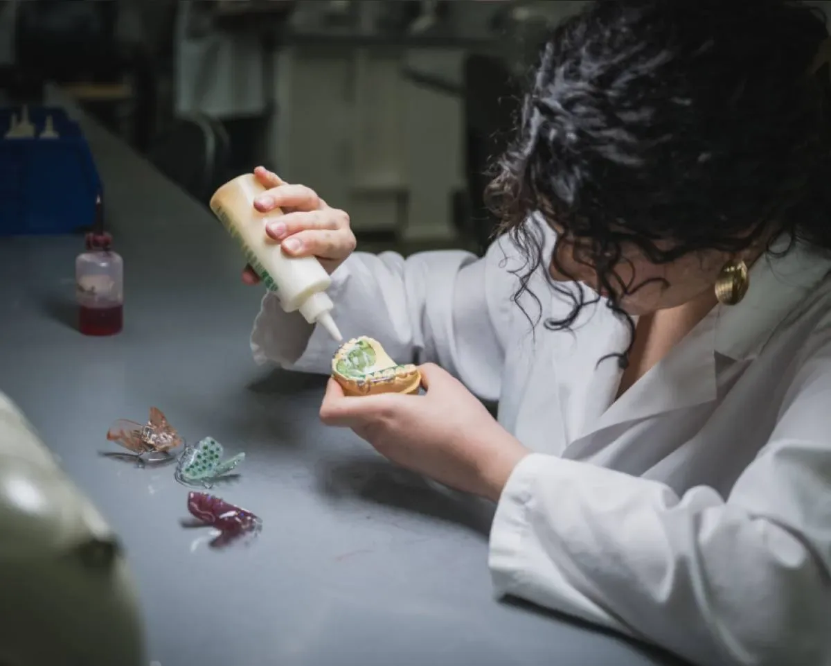 Étudiante qui manipule de la colle et des dents