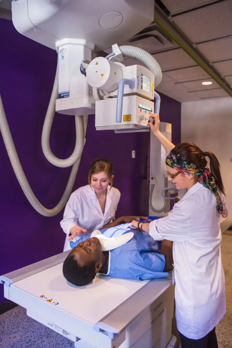 Étudiantes qui se pratiquent à passer une radio à un patient