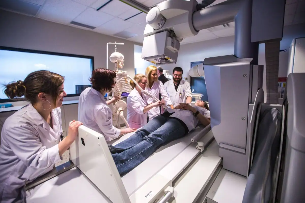 Personnes étudiantes qui discutent autour d'un patient allongé