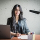 Étudiante qui prend des notes face caméra