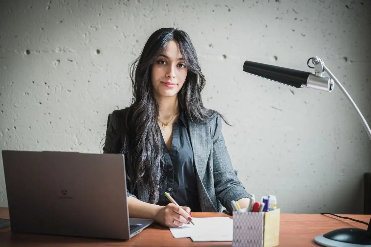 Étudiante qui prend des notes face caméra