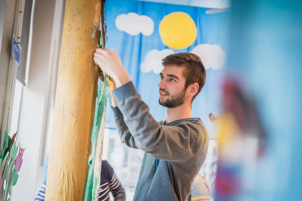 Étudiant qui accroche les travaux des enfants