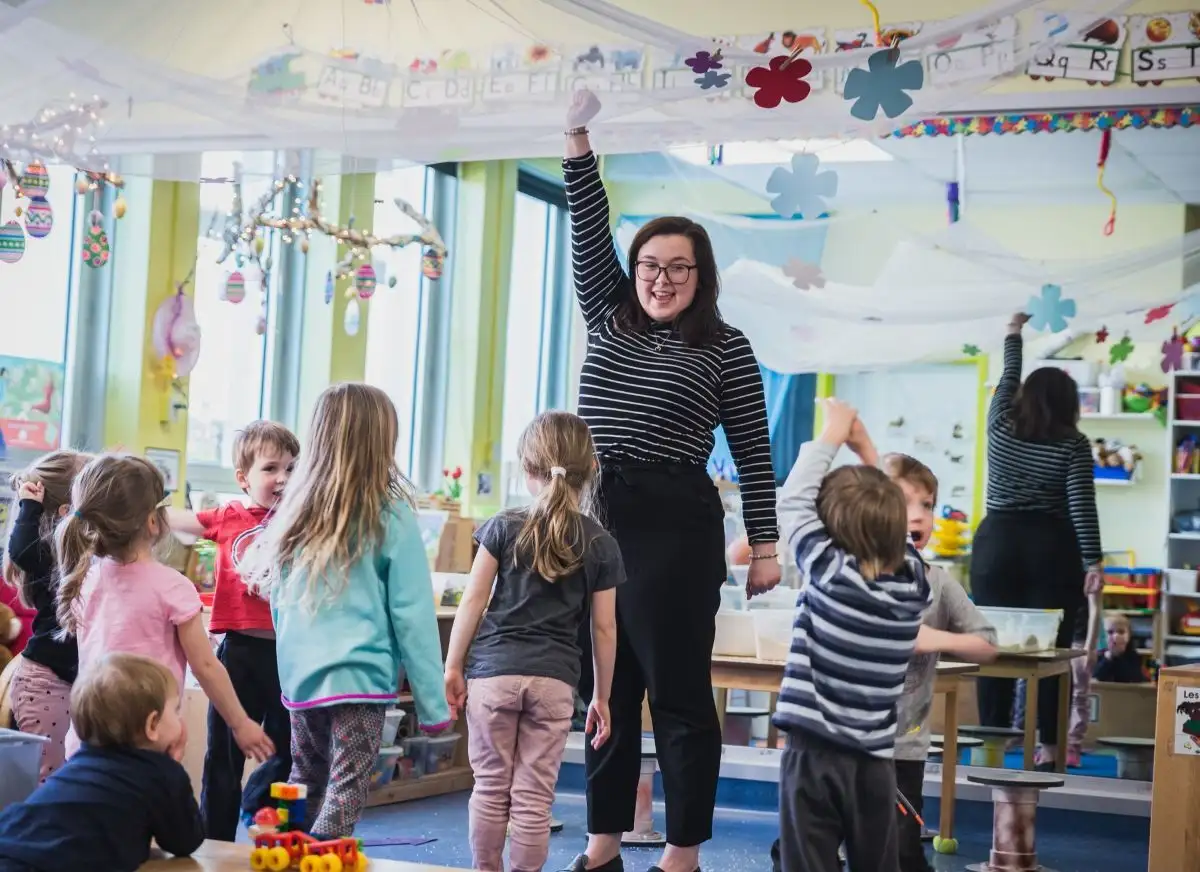 Éducatrice qui fait une activité debout avec les enfants