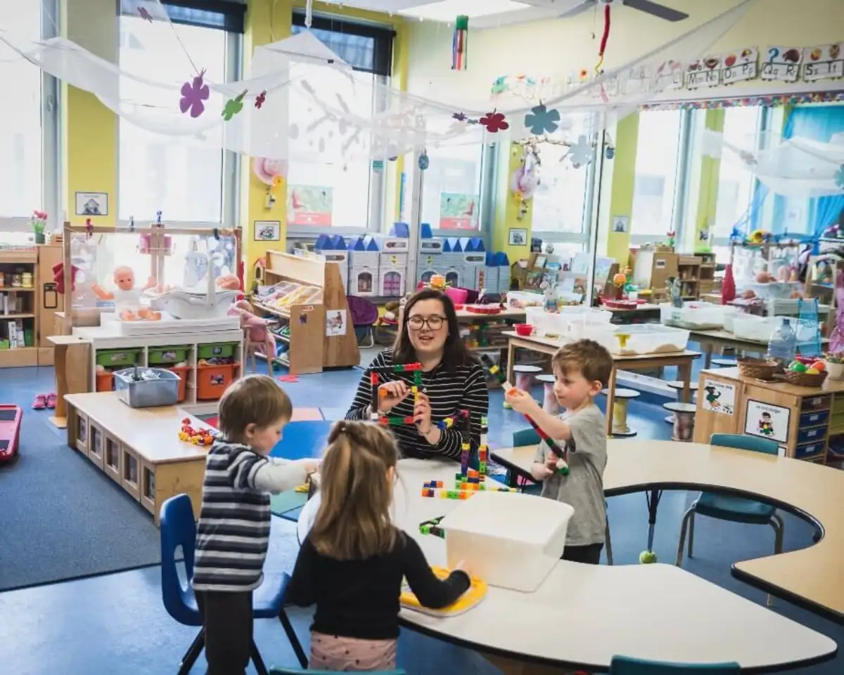 Éducatrice qui fait une activité à table avec des enfants