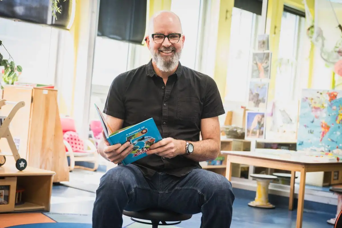 Éducateur en petite enfance qui tient un livre