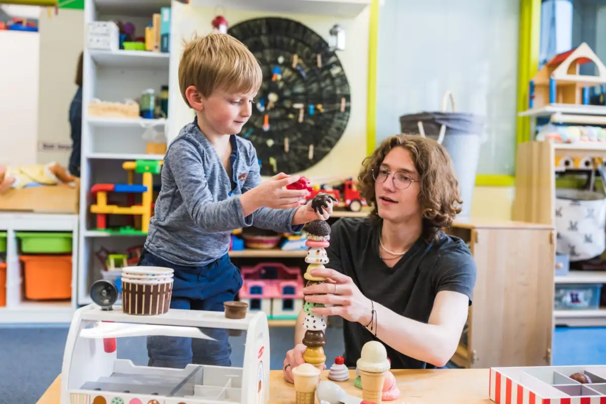 Étudiant qui joue avec un enfant à empiler des objects