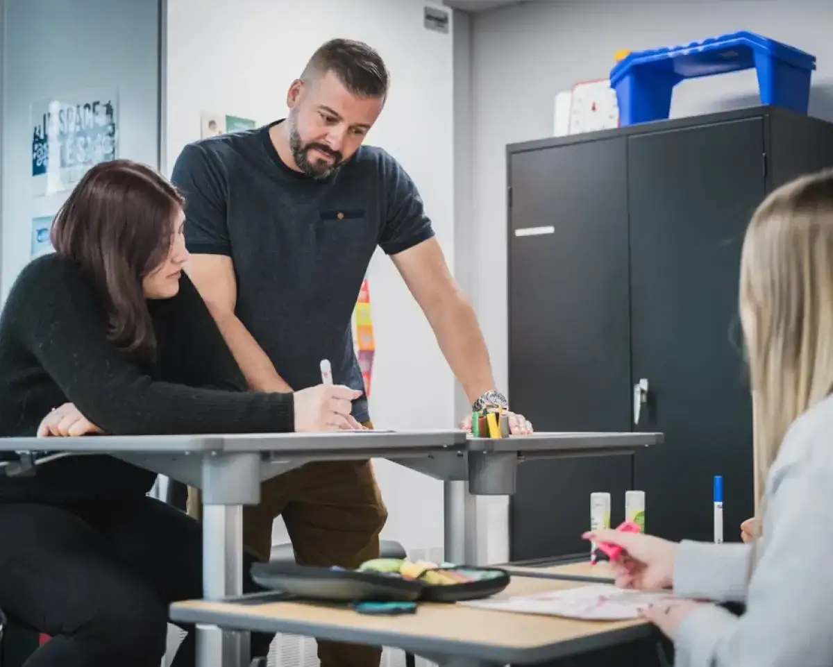 Enseignant qui discute avec son élève à son bureau